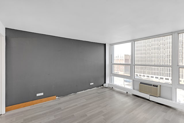 empty room with cooling unit and light hardwood / wood-style flooring