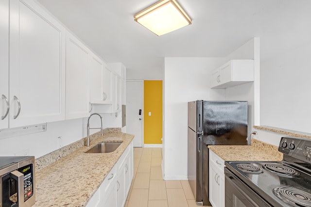 kitchen with light stone counters, light tile patterned floors, sink, white cabinetry, and black appliances