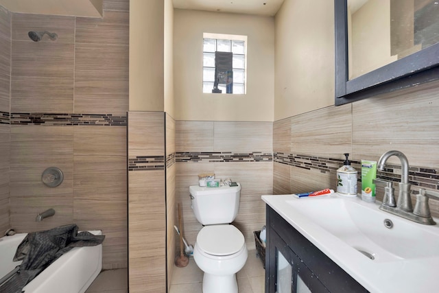 full bathroom featuring vanity, tile patterned floors, toilet, tile walls, and tiled shower / bath combo