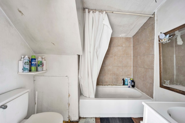 full bathroom featuring vanity, a textured ceiling, vaulted ceiling, toilet, and shower / bathtub combination with curtain