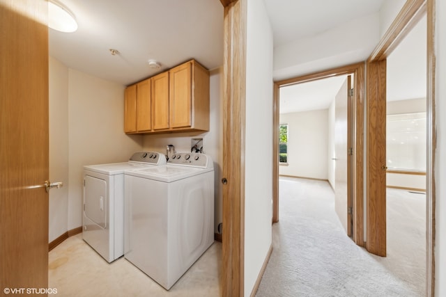 washroom with washer and dryer, cabinets, and light carpet