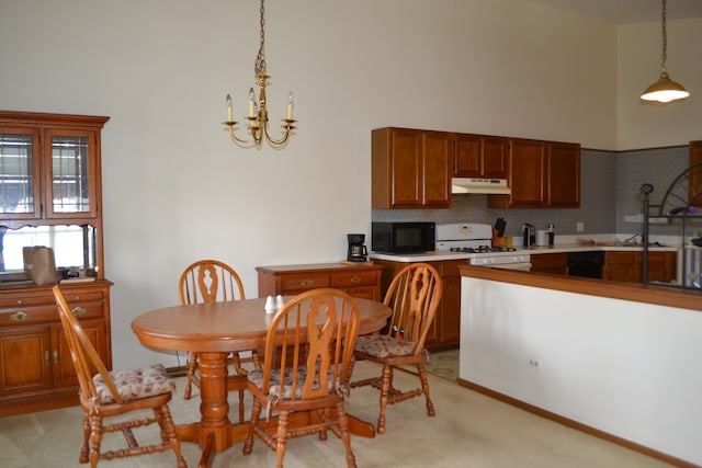 kitchen with a towering ceiling, decorative light fixtures, white gas range, and light carpet