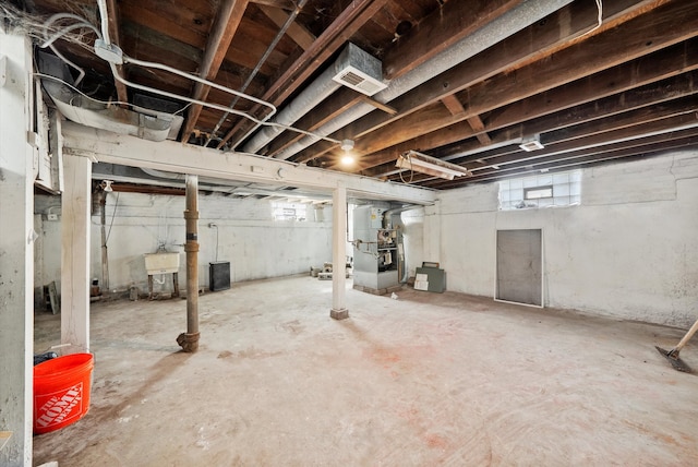 basement featuring sink and heating unit