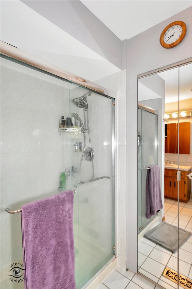 bathroom featuring a shower with door, vanity, and tile patterned floors