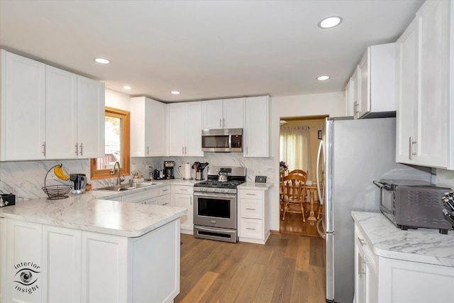 kitchen with white cabinetry, stainless steel appliances, sink, and light wood-type flooring