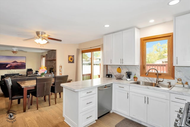 kitchen featuring kitchen peninsula, white cabinetry, light wood-type flooring, dishwasher, and sink