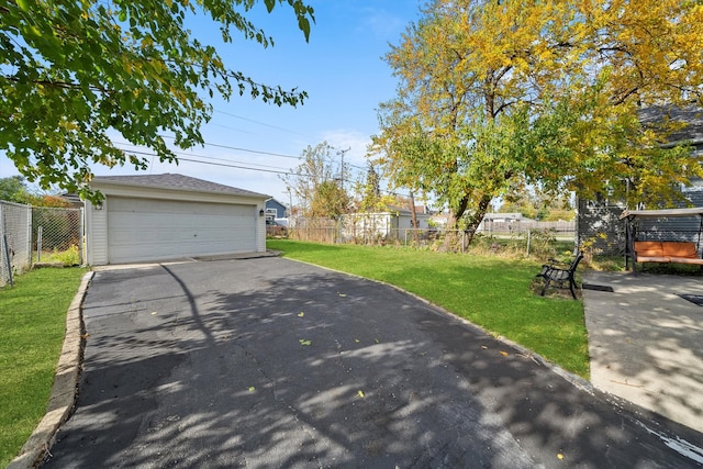 view of front of home featuring a garage, a front lawn, and an outbuilding