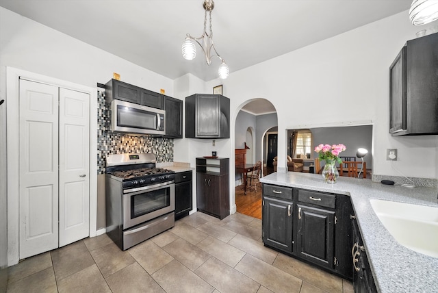 kitchen featuring sink, decorative light fixtures, a notable chandelier, and stainless steel appliances