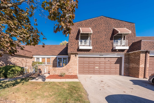 view of front of property featuring a balcony and a garage