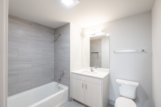 full bathroom featuring vanity, tiled shower / bath combo, and toilet