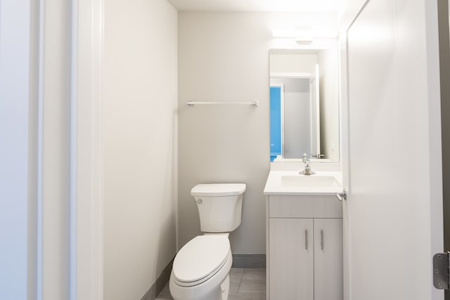 bathroom featuring vanity, tile patterned flooring, and toilet