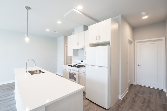 kitchen with hanging light fixtures, white cabinetry, white appliances, and a center island with sink