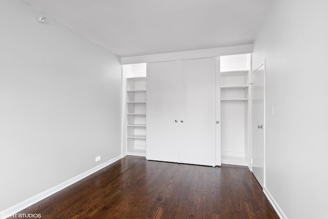 unfurnished bedroom with dark wood-type flooring