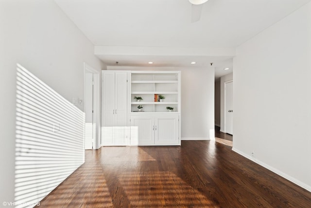 unfurnished living room featuring ceiling fan, built in features, and dark hardwood / wood-style floors