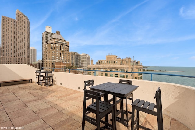 view of patio / terrace with a water view and a balcony