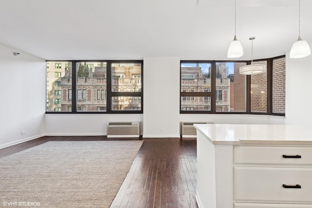 unfurnished living room featuring dark hardwood / wood-style flooring and an AC wall unit