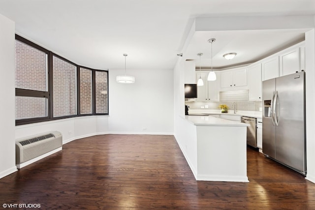 kitchen with tasteful backsplash, hanging light fixtures, white cabinets, and stainless steel appliances