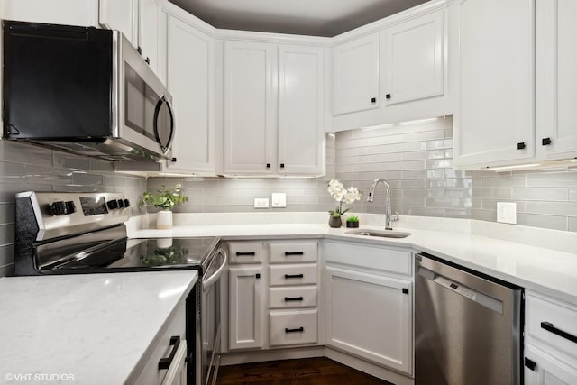 kitchen featuring decorative backsplash, white cabinetry, sink, and appliances with stainless steel finishes