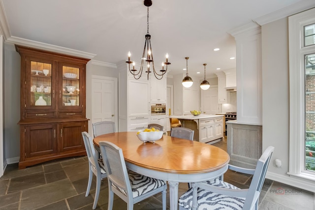 dining area featuring plenty of natural light, ornamental molding, and a chandelier