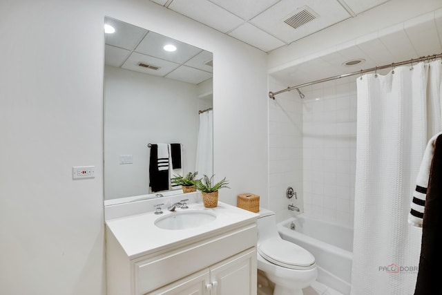 full bathroom with vanity, a drop ceiling, toilet, and shower / bath combo with shower curtain