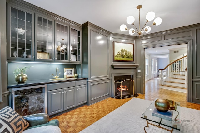 living room with indoor wet bar, a chandelier, beverage cooler, and light parquet flooring