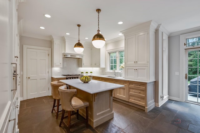 kitchen featuring a kitchen island, decorative light fixtures, tasteful backsplash, sink, and white cabinets