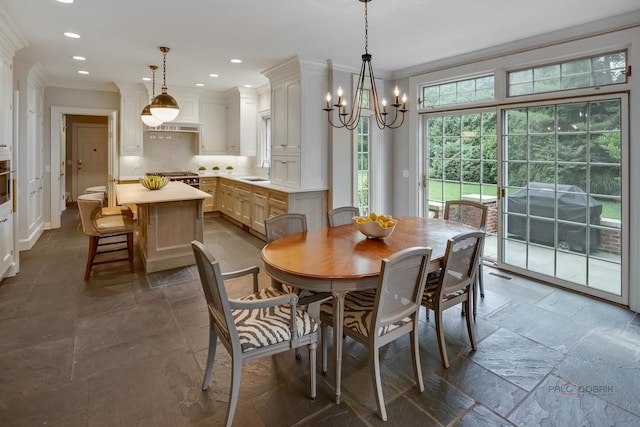 dining space featuring ornamental molding, a chandelier, and sink