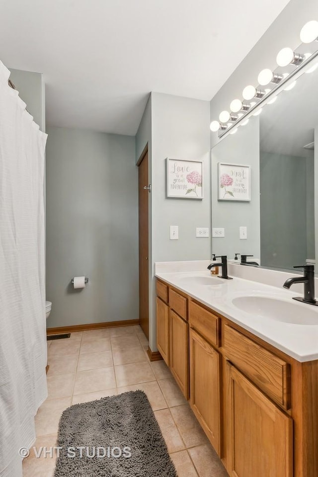 bathroom featuring tile patterned flooring, vanity, and toilet