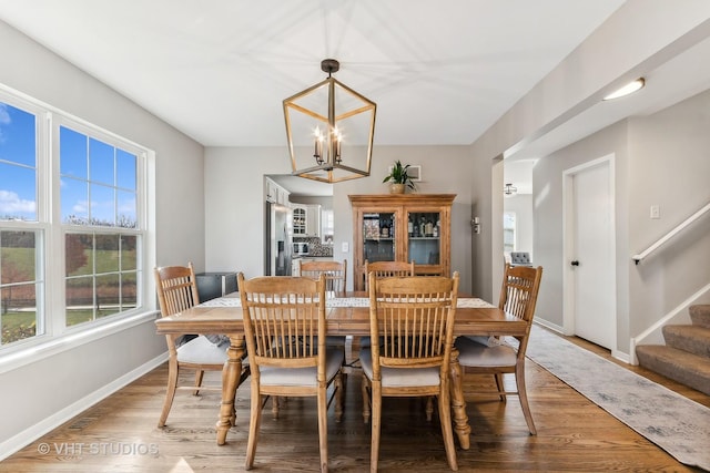 dining space featuring hardwood / wood-style flooring and a notable chandelier