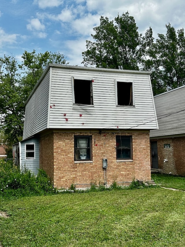 rear view of house featuring a lawn