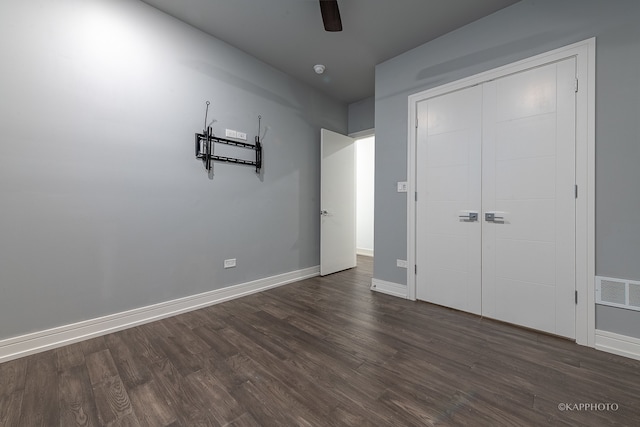 unfurnished bedroom featuring a closet, ceiling fan, and dark wood-type flooring