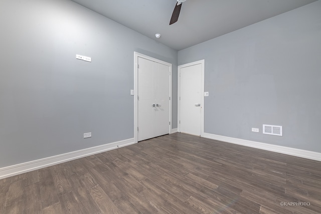 spare room featuring ceiling fan and dark wood-type flooring