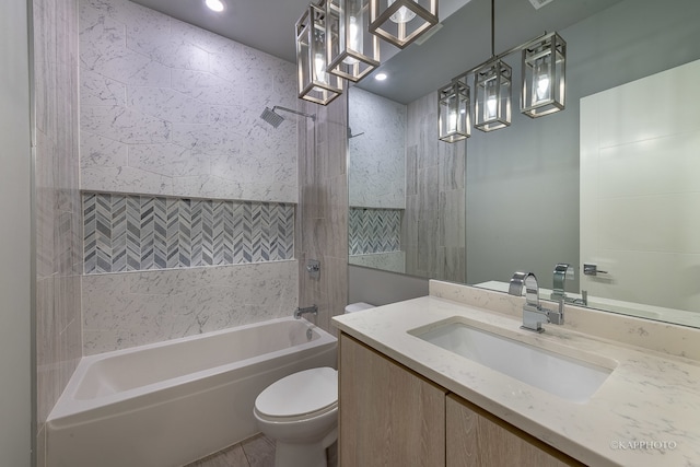 full bathroom with tile patterned floors, vanity, tiled shower / bath combo, and toilet