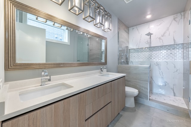 bathroom featuring tiled shower, vanity, toilet, and tile walls