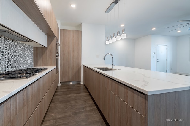 kitchen featuring decorative backsplash, dark hardwood / wood-style flooring, stainless steel appliances, sink, and hanging light fixtures