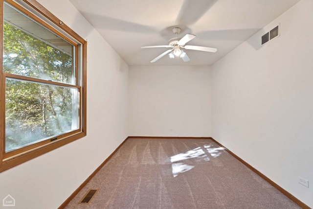 empty room with ceiling fan, carpet, and a wealth of natural light