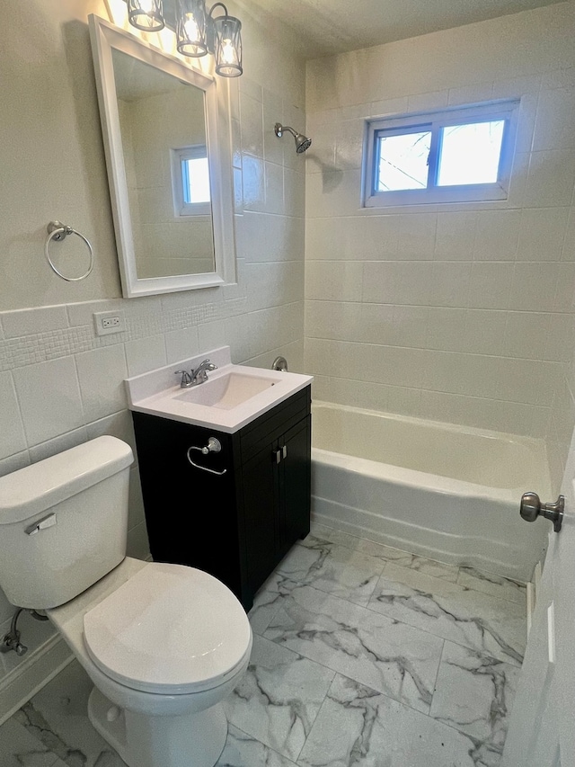 full bathroom with vanity, toilet, a healthy amount of sunlight, and tiled shower / bath combo