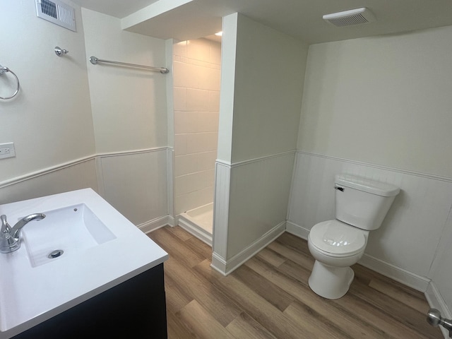 bathroom with toilet, walk in shower, vanity, and wood-type flooring