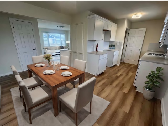 dining room with wood-type flooring and sink