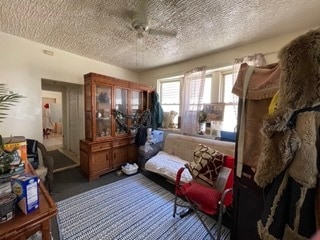 sitting room with ceiling fan and a textured ceiling