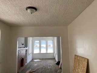 unfurnished living room with a textured ceiling and a fireplace