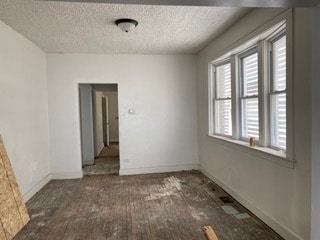 unfurnished room featuring dark hardwood / wood-style floors and a textured ceiling