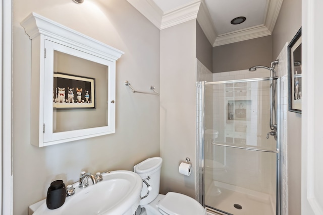 bathroom with toilet, crown molding, a shower stall, and a sink