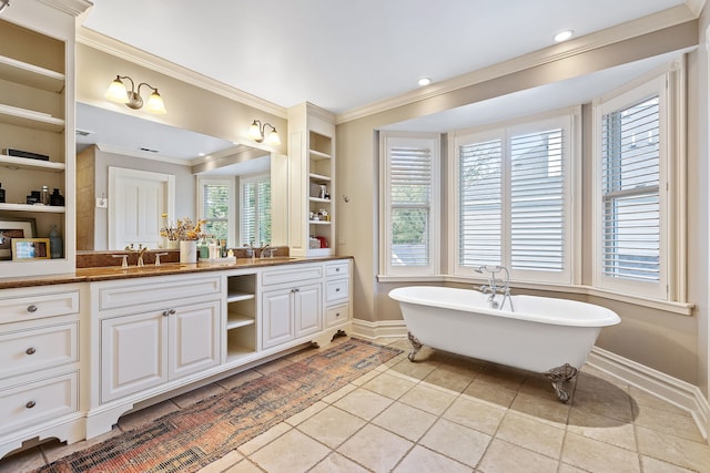 full bath featuring a sink, baseboards, ornamental molding, a soaking tub, and double vanity