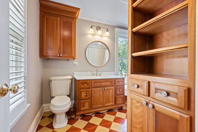 bathroom featuring toilet, tile patterned floors, baseboards, and vanity