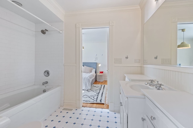 ensuite bathroom with connected bathroom, a wainscoted wall,  shower combination, crown molding, and vanity