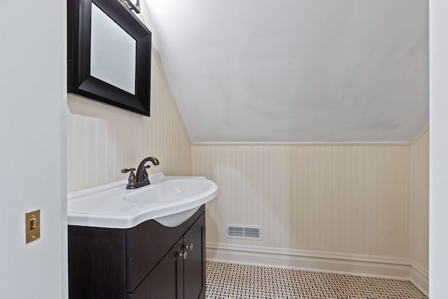 bathroom with lofted ceiling, visible vents, and vanity