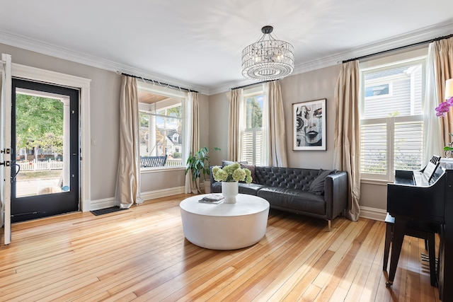 living area with a healthy amount of sunlight, light wood-style floors, and ornamental molding