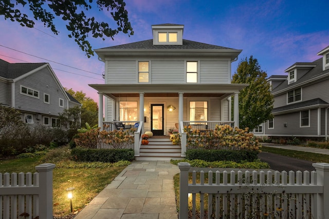 american foursquare style home featuring a porch