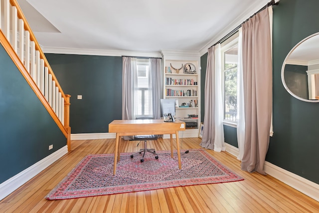 home office with light wood-style floors, baseboards, and crown molding